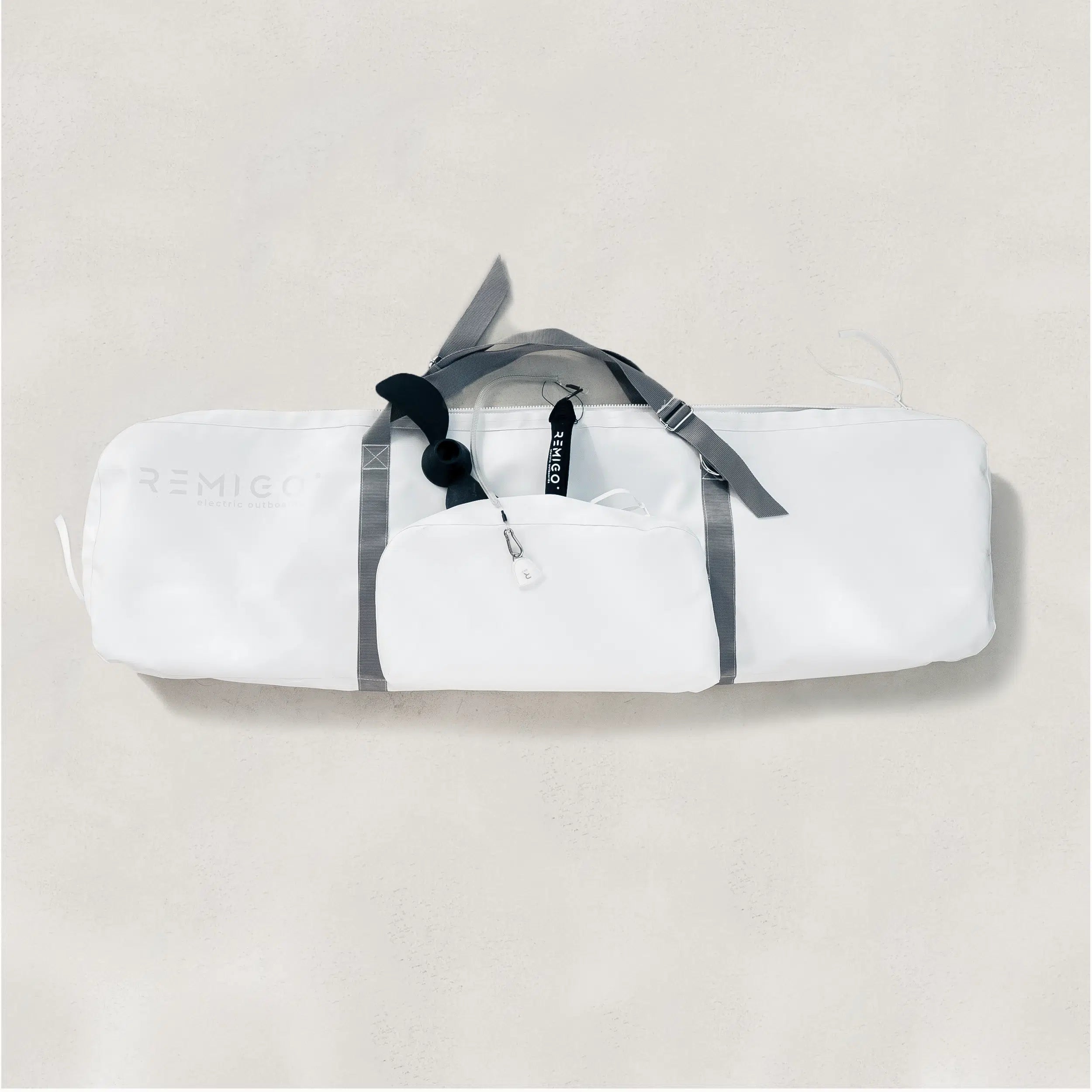 White bag with gray straps on a light beige background