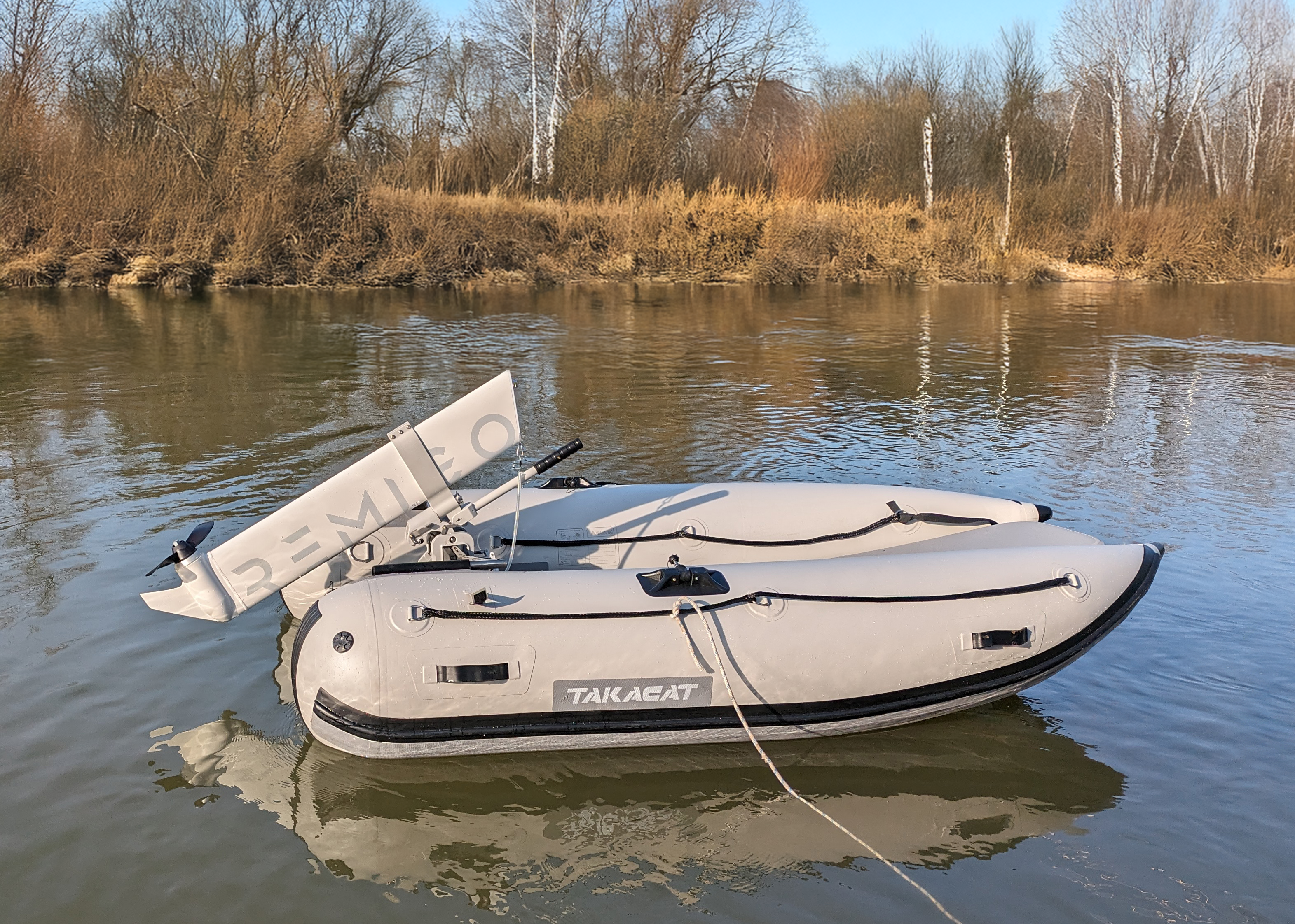 Inflatable boat on a calm body of water with trees in the background with Remigo engine fitted