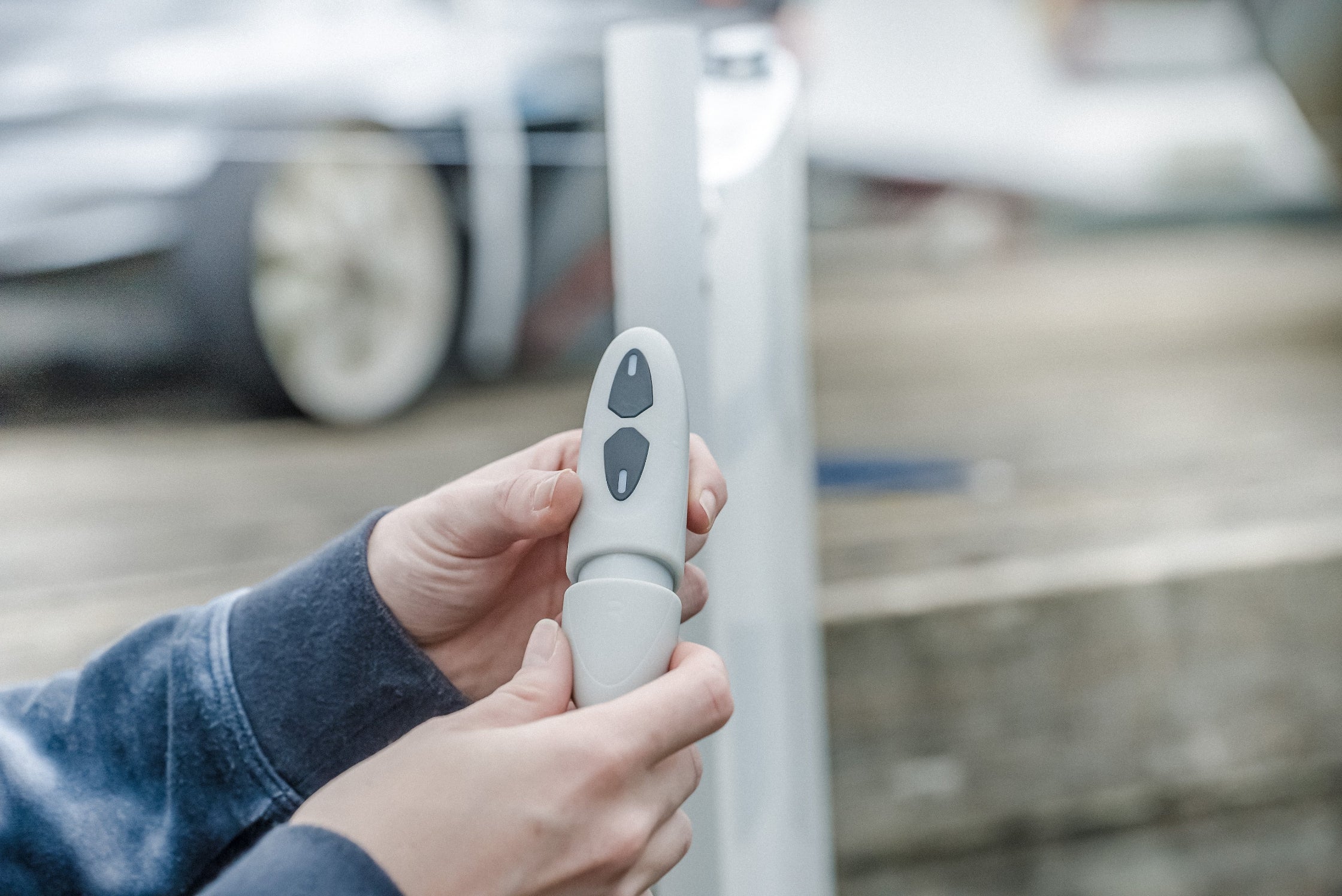 Person holding a white remote control with a blurred background