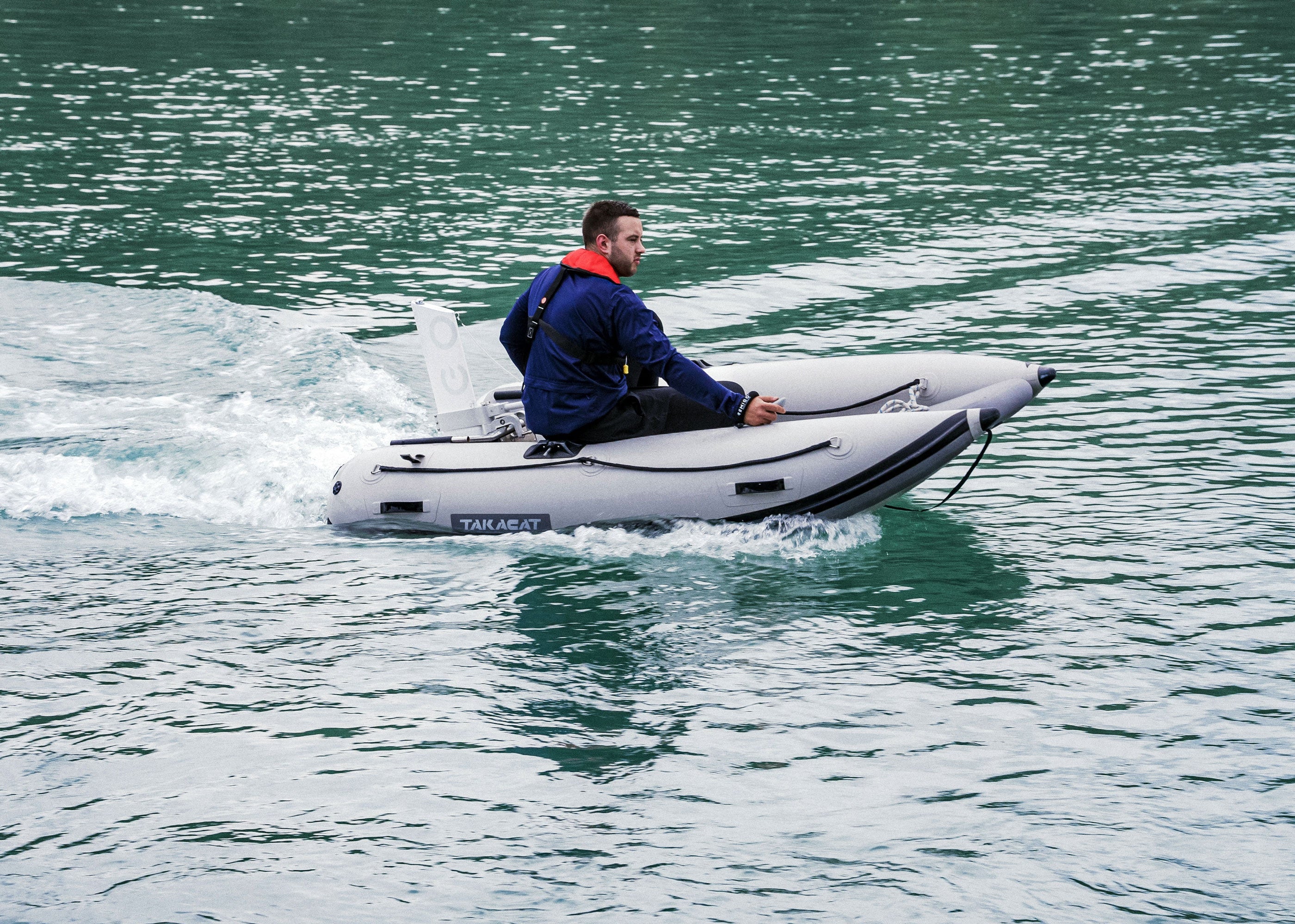 Man on a small inflatable boat in a body of water with Remigo fitted