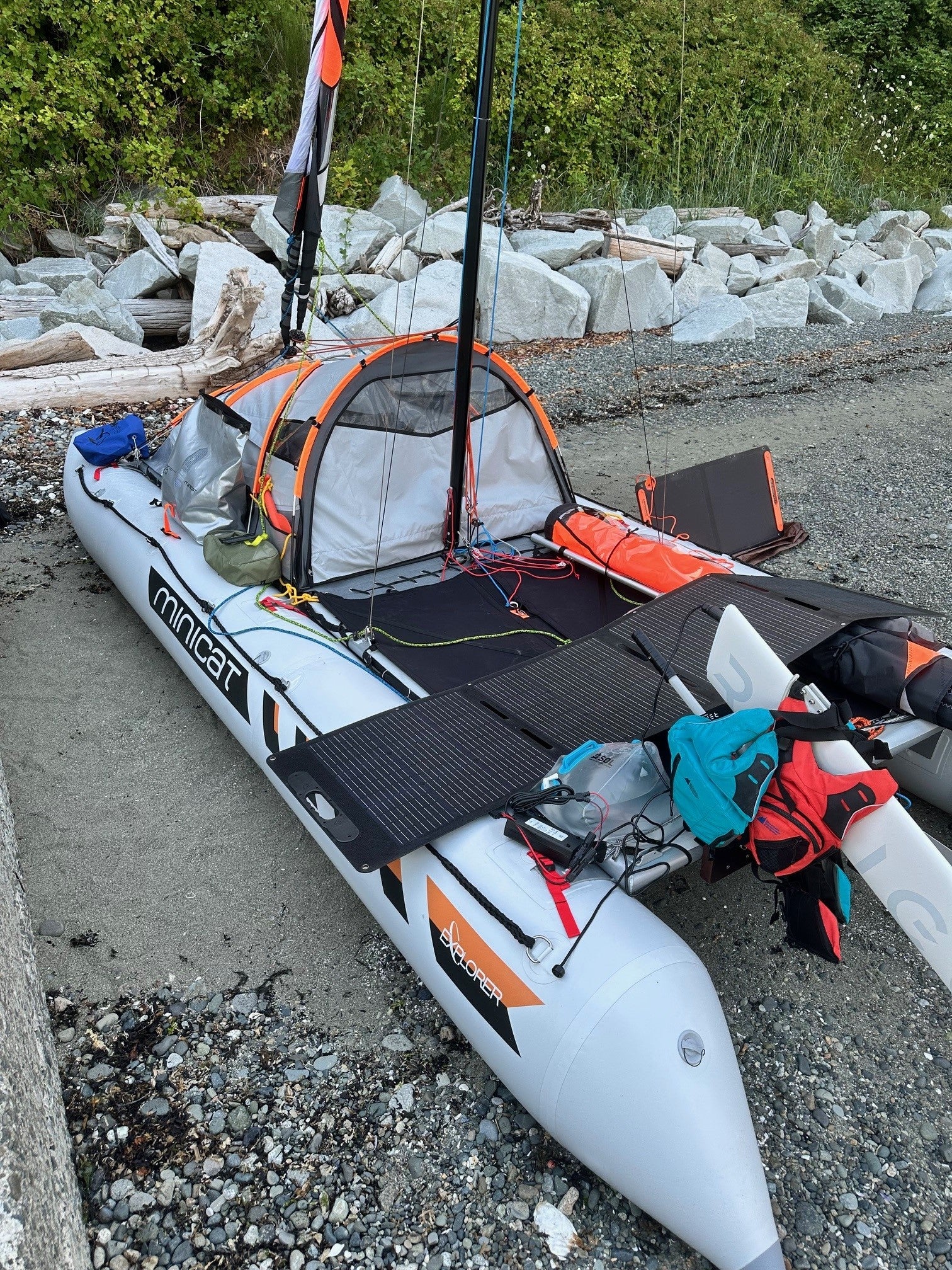 Inflatable catamaran 520 Explorer with solar panels and Remigo on a rocky shoreline