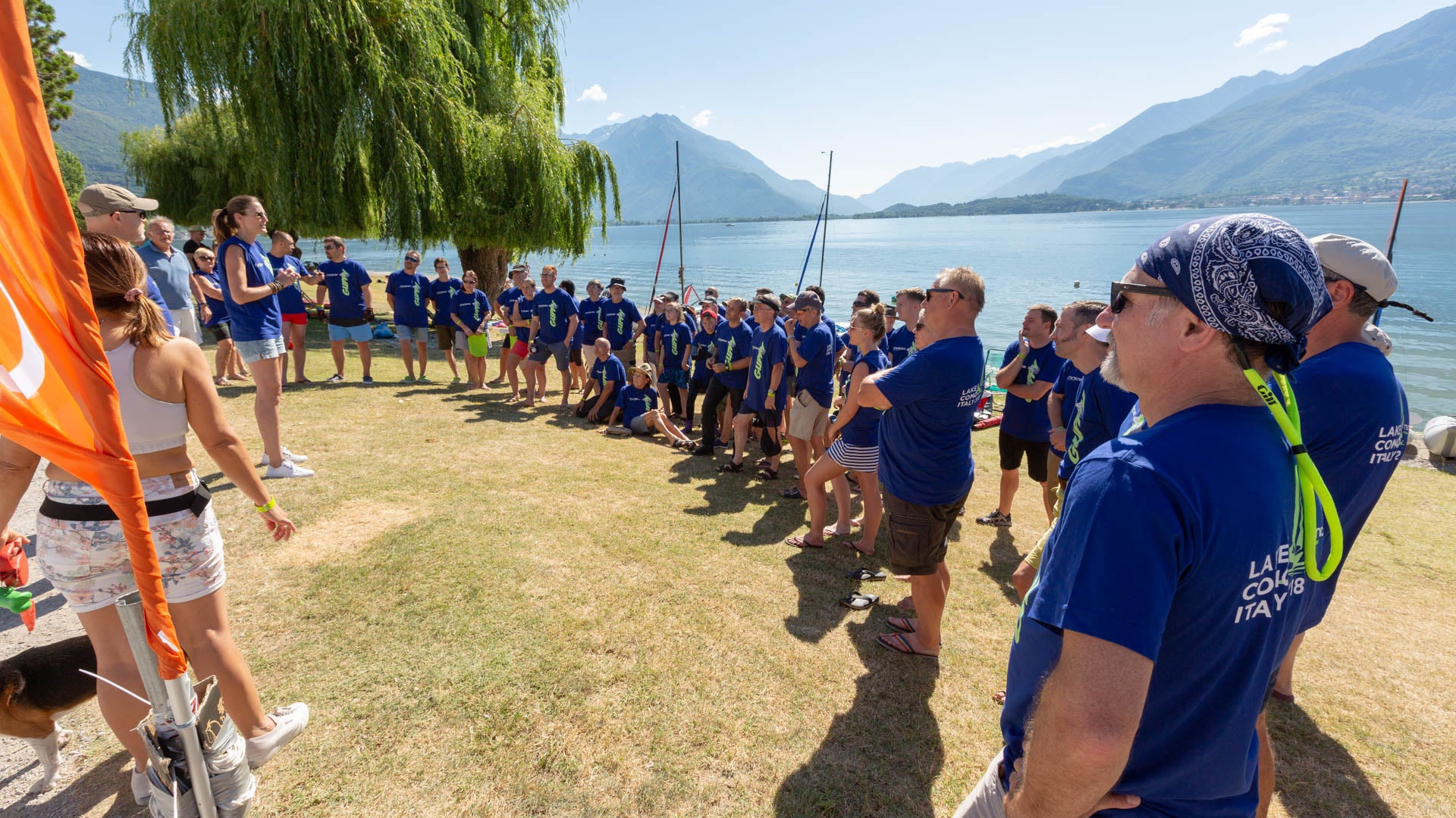 Group of MiniCat customers on blue MiniCat branded T-shirts with MiniCat boats in background
