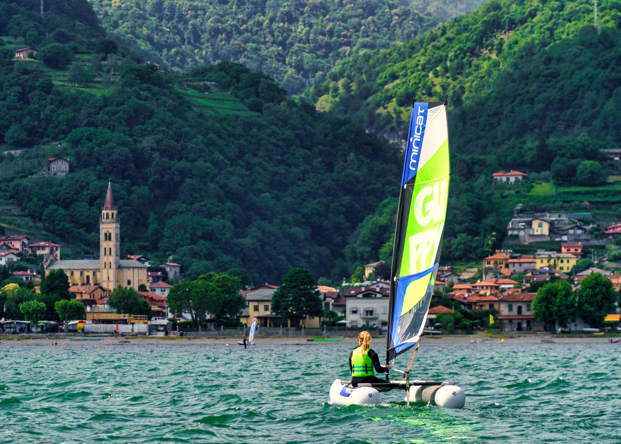 Dinghy MiniCat Guppy sailed by a girl at the lake Como in Italy