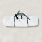 White bag with gray straps on a light beige background