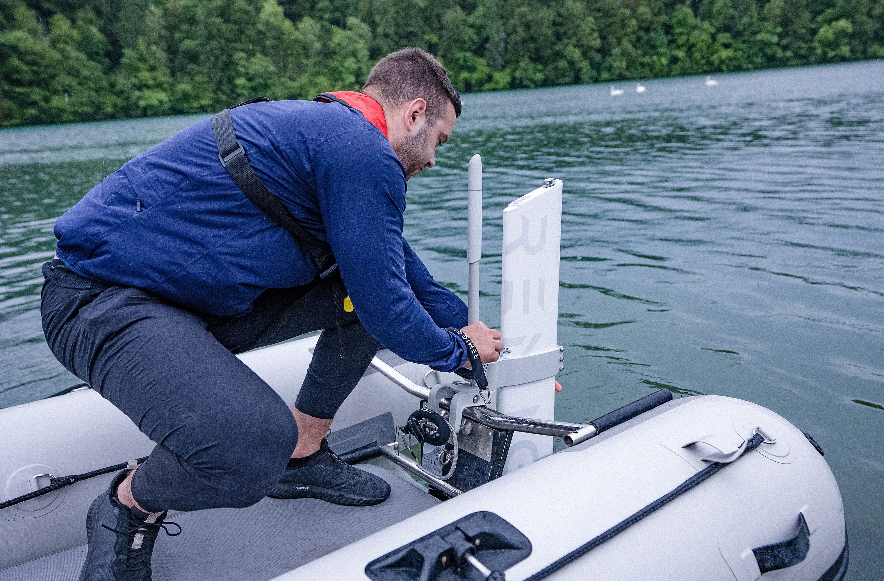 Person securing a Remigo electric outboard on the boat
