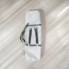 White bag with gray straps on a light beige background