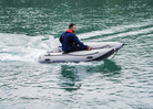 Man on a small inflatable boat in a body of water with Remigo fitted